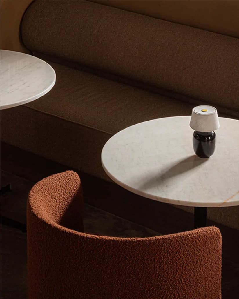 Warm interior detail — boucle chair and marble table